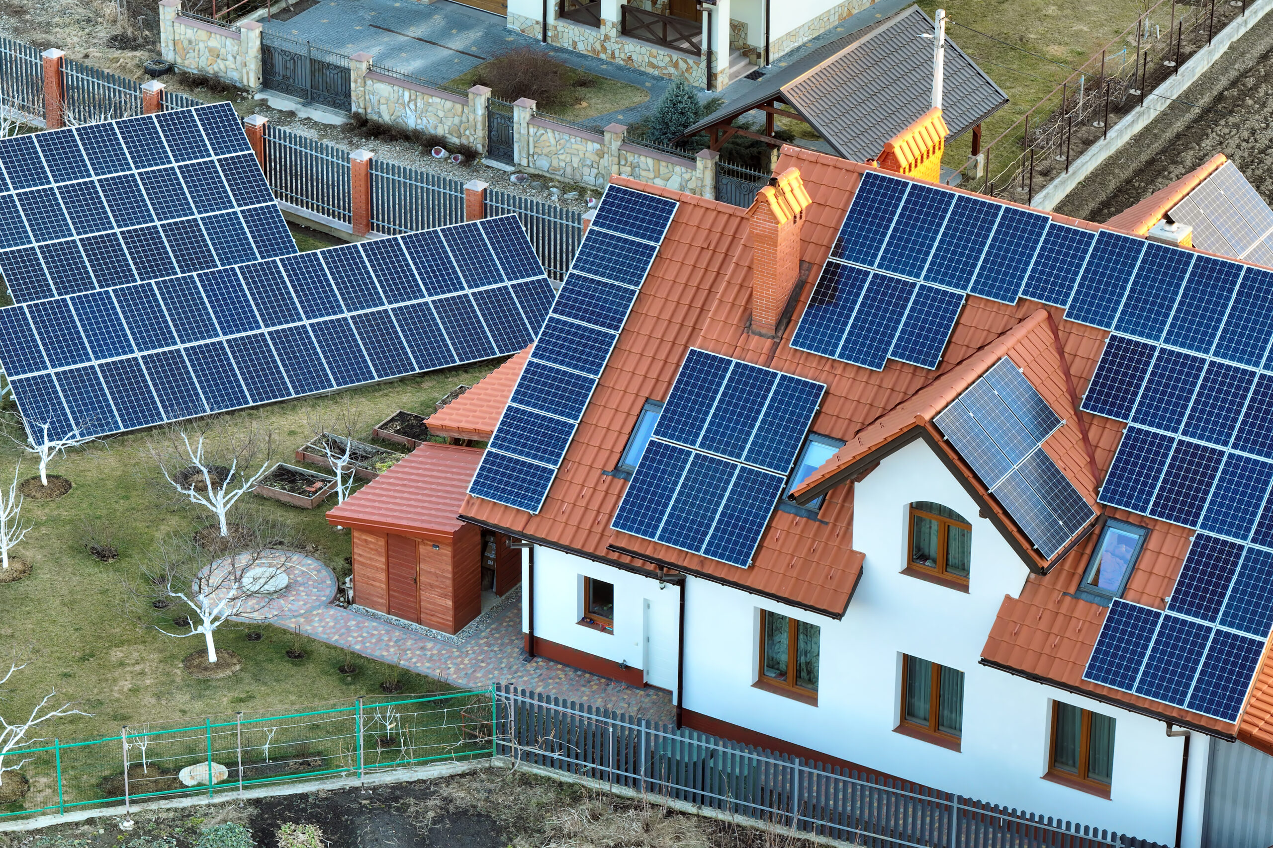 residential house with rooftop covered with solar photovoltaic panels for producing of clean ecological electrical energy in suburban rural area. concept of autonomous home